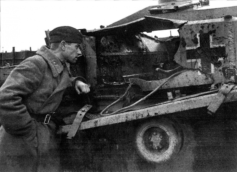 Советский солдат осматривает поврежденный немецкий StuG III Ausf.F. Разрыв в броне позволяет заглянуть внутрь самоходки.